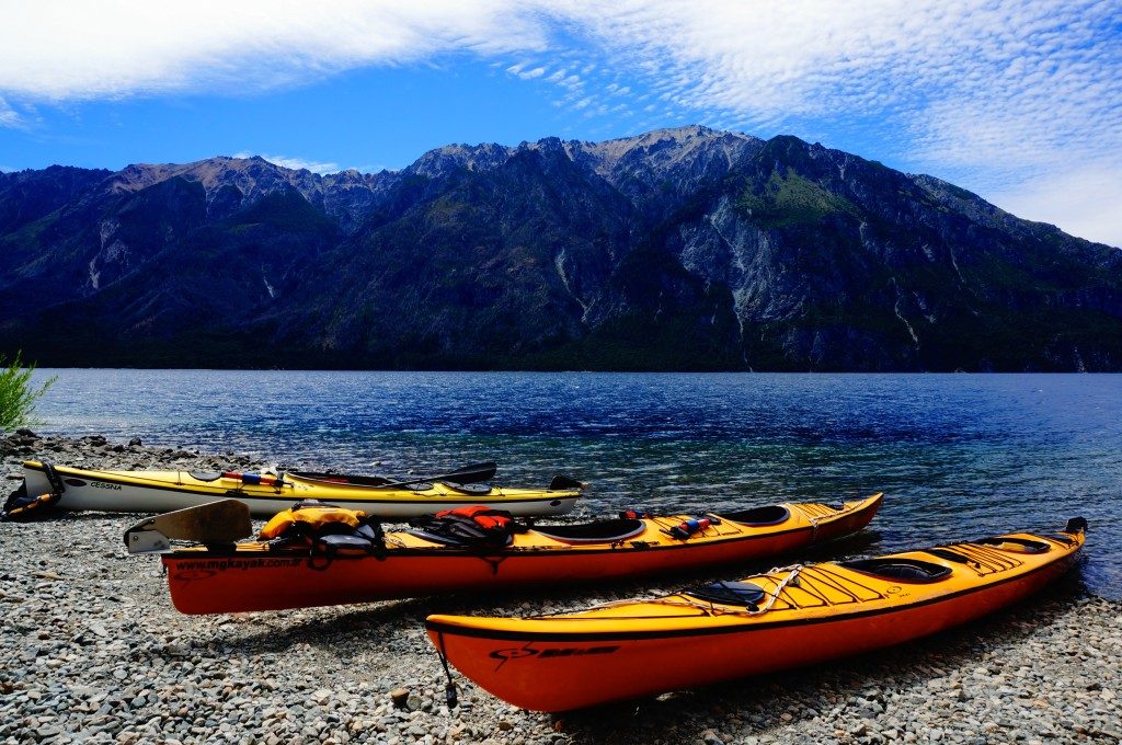 Kayaks along shore of Lago Epuyen (Lake Epuyen) with Andes mountains