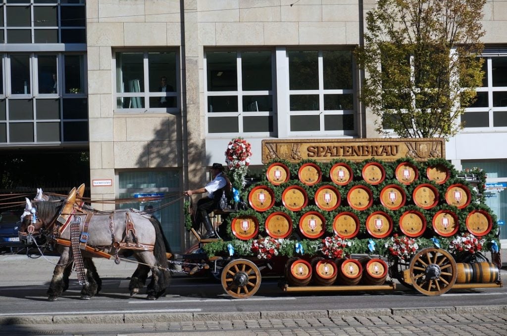 Spaten horses with wagon deliver wooden beer kegs to Oktoberfest during free parade