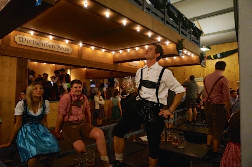 People at Oktoberfest wearing traditional dirndl and lederhosen outfits