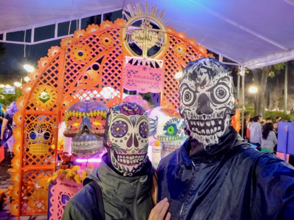 John & Heather in sugar skull masks during Day of the Dead in Mexico City