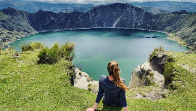 Heather sits on crater rim of Laguna Quilotoa