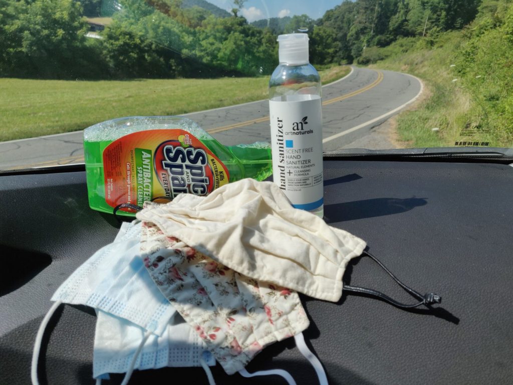 Extra supplies needed for a safer pandemic road trip include: disinfectant spray, hand sanitizer, and face masks
