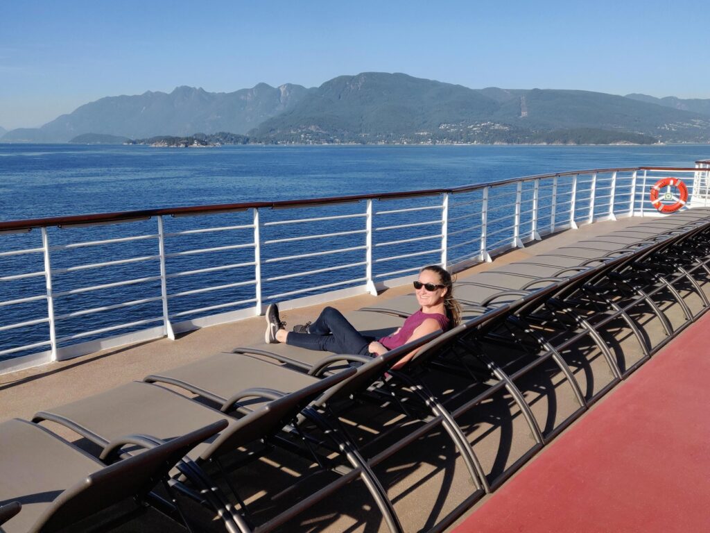 Relaxing on a lounge chair on the lido deck during a repositioning cruise